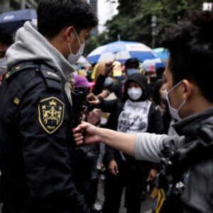 Protester reaching for police officer's gun during protest.