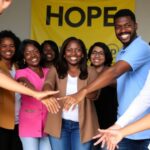 Diverse group of people united in a supportive gesture.