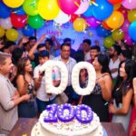 Colorful celebration with balloons and a cake for 100.