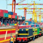 Railway yard with freight trains and workers in action.