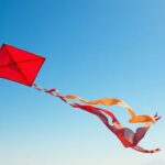 A colorful kite flying in a blue sky.
