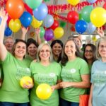 Volunteers celebrating with balloons at a fundraising event.