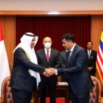Delegates from UAE and Malaysia shaking hands in ceremony.