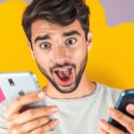 Person surprised while checking phone for important updates.