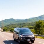 A modern vehicle on the scenic CA-2 Occidente highway.