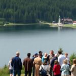 Diverse group collaborating in a Swedish natural landscape.