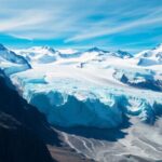 Aerial view of glaciers with mountains and blue skies.