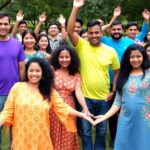 Diverse group of people celebrating unity and resilience outdoors.