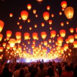 People celebrating with glowing lanterns at night in Cambodia.