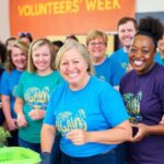 Diverse volunteers smiling and working together at an event.