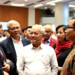 Diverse leaders in formal attire discussing in Jakarta conference.