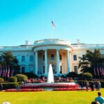 The White House with flags and people gathered outside.