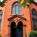 Historic Black church with stained glass and greenery.