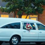 Hearse with flowers outside a community center.