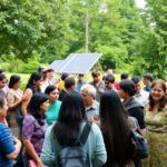 Community members discussing renewable energy in a park.