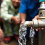Clean water flowing from a tap in a community setting.