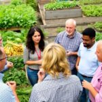 Food system leaders discussing amidst fresh produce and urban agriculture.