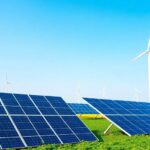 Solar panels and wind turbines in a green landscape.