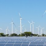 Renewable energy landscape with wind turbines and solar panels.