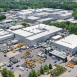 Workers at Brampton plant with modern machinery and greenery.