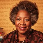 Toni Morrison with books, evoking her literary legacy.