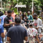 Diverse community members engaged in collaborative activities outdoors.