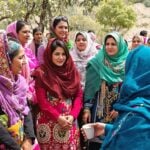 Afghan women and girls united in outdoor discussion.