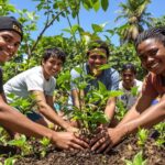 Diverse youth planting trees in a green landscape.