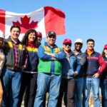 Diverse group of Canadian workers standing united outdoors.