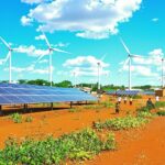 Solar panels and wind turbines in an African landscape.