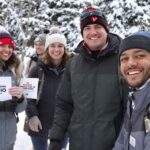 Volunteers canvassing outdoors in winter attire and snow.