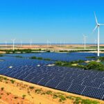 Solar panels and wind turbines in an African landscape.