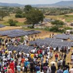 Diverse group of people discussing renewable energy in Tanzania.