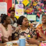 Diverse women collaborating in a vibrant workspace.