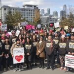 Diverse group rallying for fair wages in education sector.