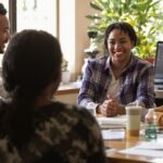 Diverse individuals engaged in discussion around a table.