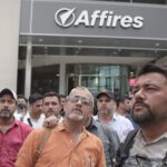 Frustrated workers gathered outside a corporate office building.