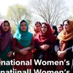 Afghan women in colorful attire discussing outdoors.