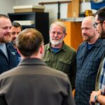 Skilled trades professionals in discussion during a meeting.
