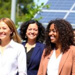 Diverse women in professional attire discussing energy initiatives.