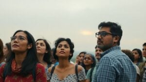 People looking at a hazy horizon under cloudy skies.