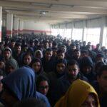 Overcrowded foreigner center with distressed individuals.