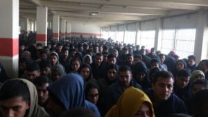 Overcrowded foreigner center with distressed individuals.