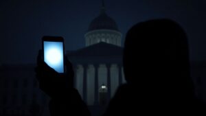 Egyptian government building with a person holding a glowing smartphone.