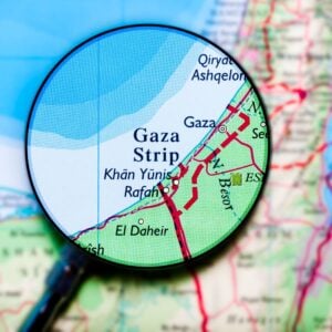 Close-up of a map zoomed in on the Gaza Strip, with Khan Yunis and Rafah visible under a magnifying glass.
