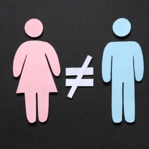 Pink female and blue male silhouettes with a not-equal sign between them, illustrating gender inequality.