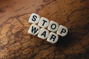 Blocks with letters S T O P W A R spell out 'STOP WAR' resting on a vintage map, conveying an anti-war message.