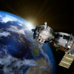 Satellite in orbit around Earth with bright sun glare at the horizon behind it