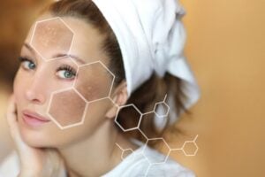 Woman with a towel on her head, touching her face, with a skincare/beauty overlay of hexagonal chemical shapes.