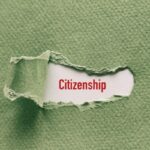 Torn green paper revealing the word Citizenship in red on white background.